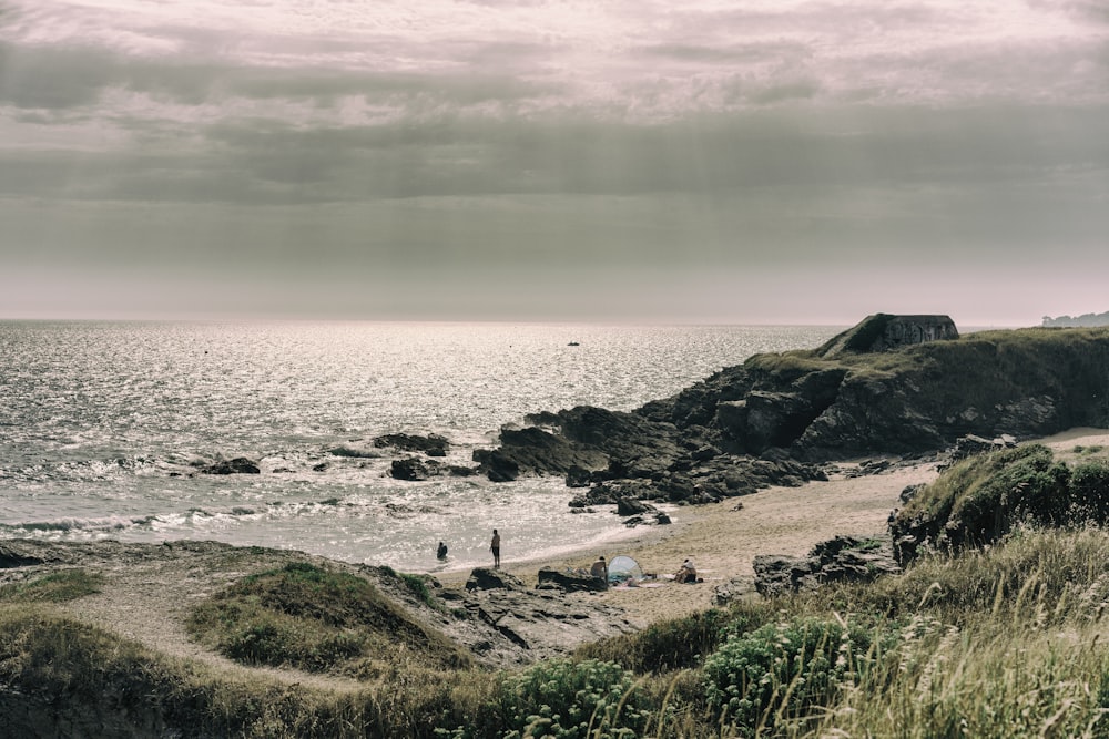 a rocky beach with a body of water in the background