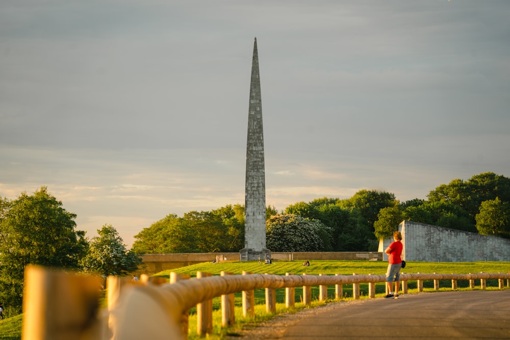 a person walking on a path towards a tall tower