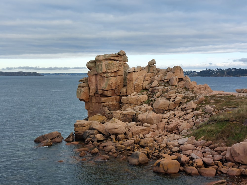 a large stack of rocks in the water