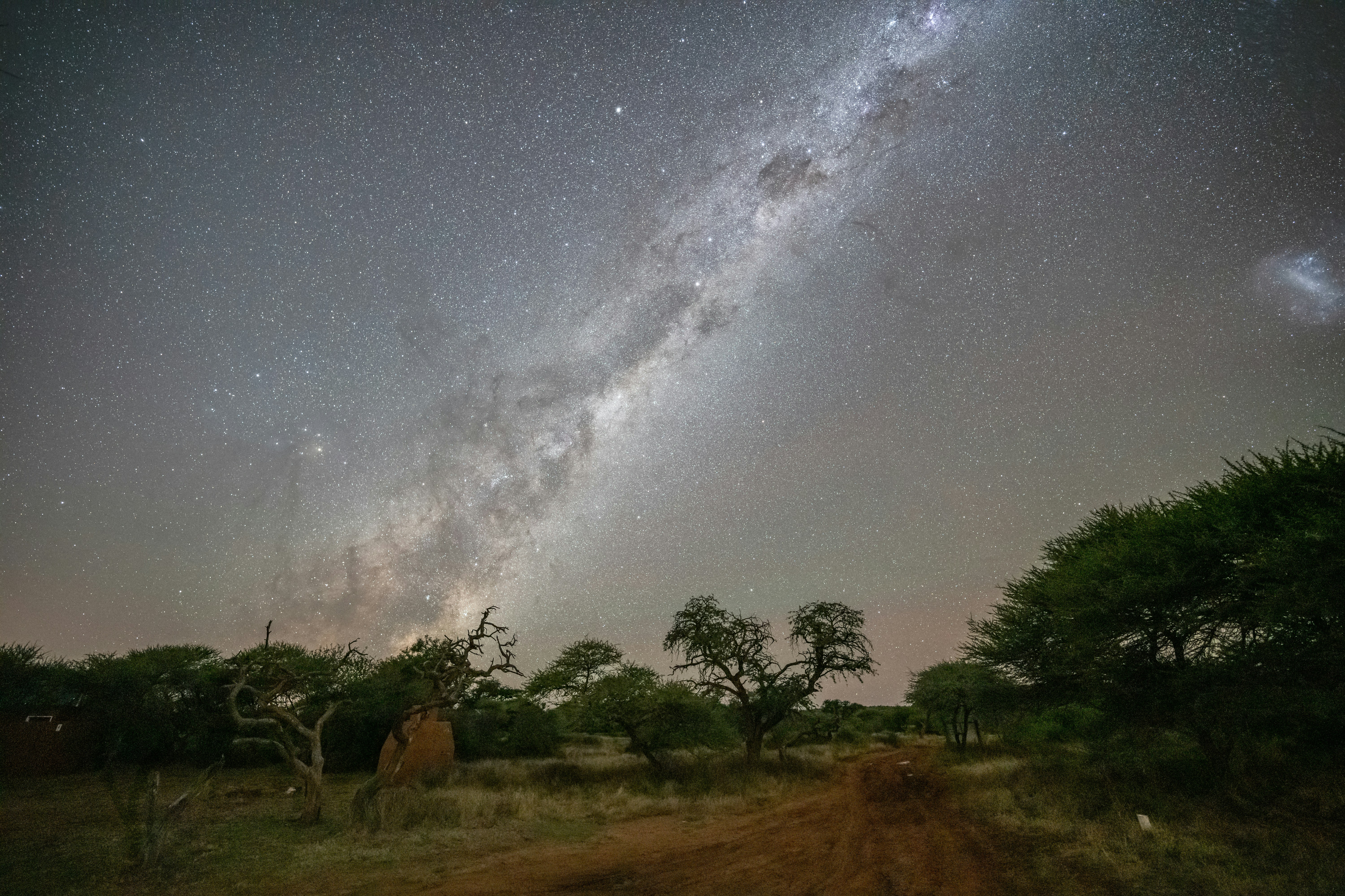Milky Way galaxy over dark landscape, deep starfield, atmospheric mist, very dark moody night sky