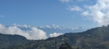 A panoramic shot capturing a multi-acre homesite with snow-capped peaks of Crystal Mountain in the distance under a clear blue sky.
