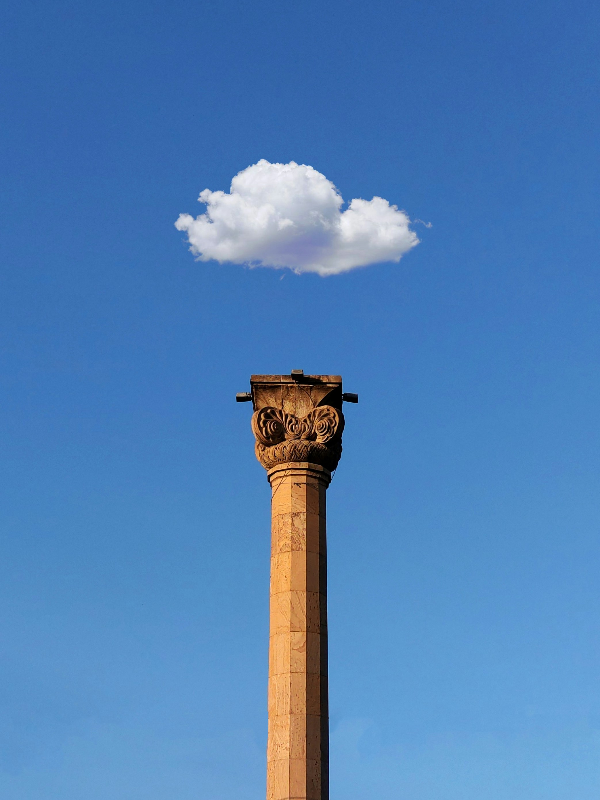 Fotomural a tall tower with a cloud in the sky