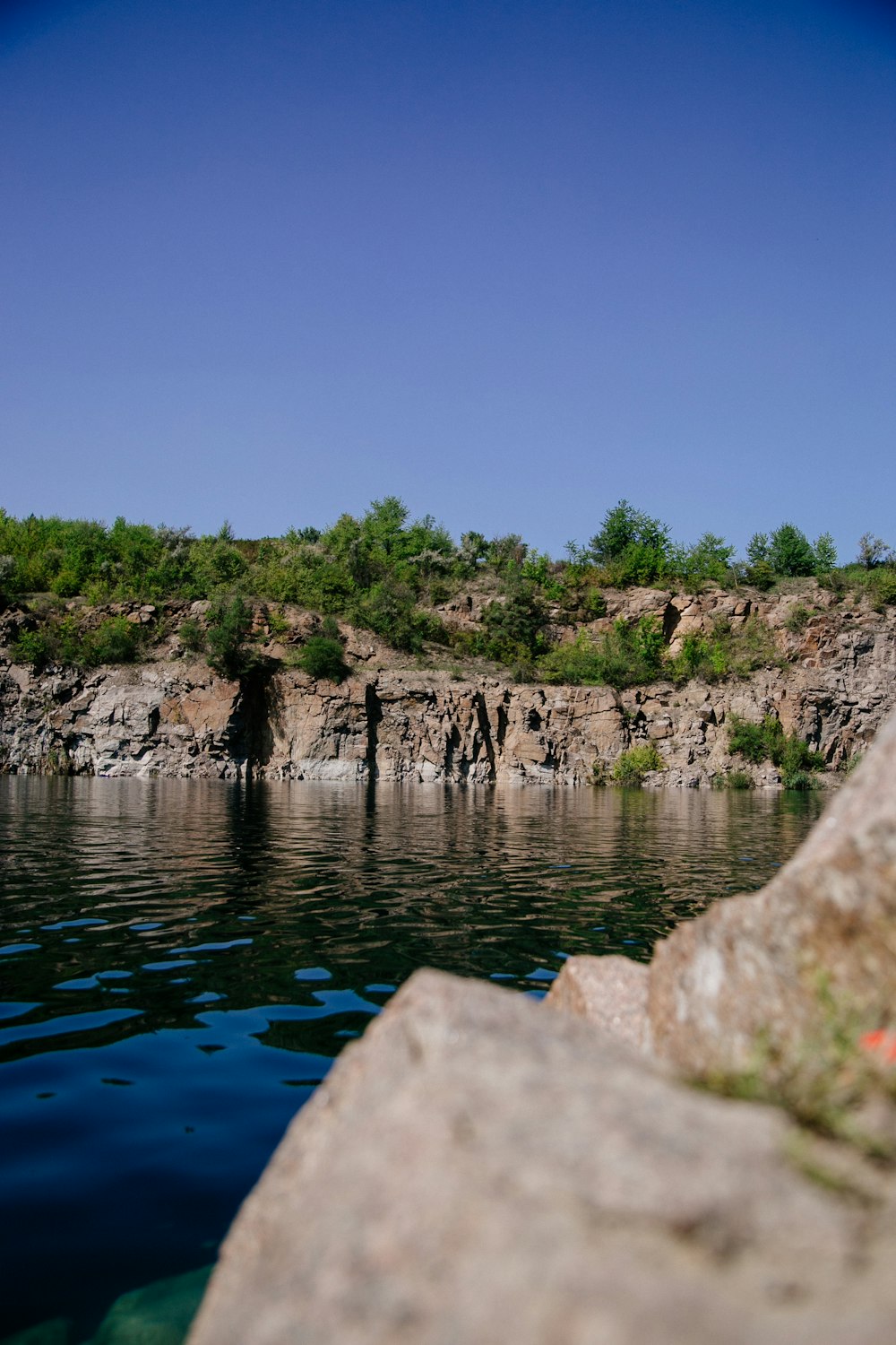 a body of water with rocks and trees around it