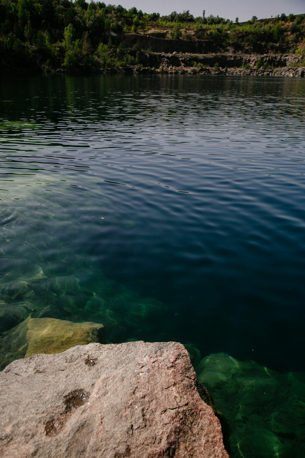 a body of water with rocks and trees around it