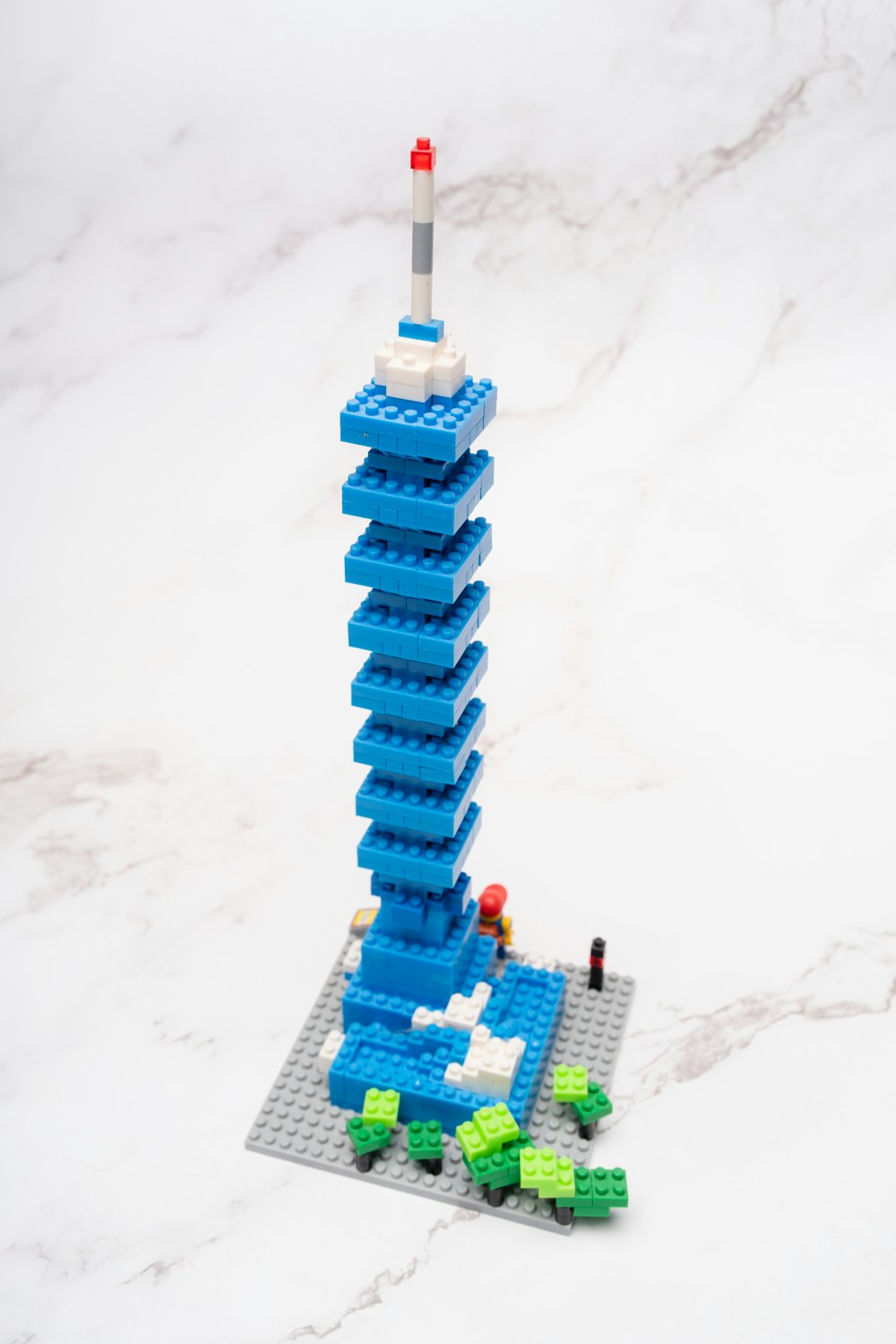 a toy building on a snowy surface with Taipei 101 in the background