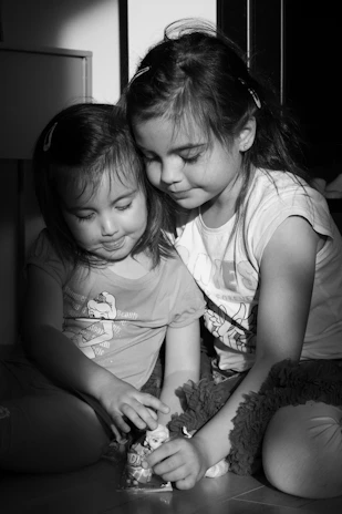 A parent and child sitting together on the floor, sharing a puzzle and laughing.