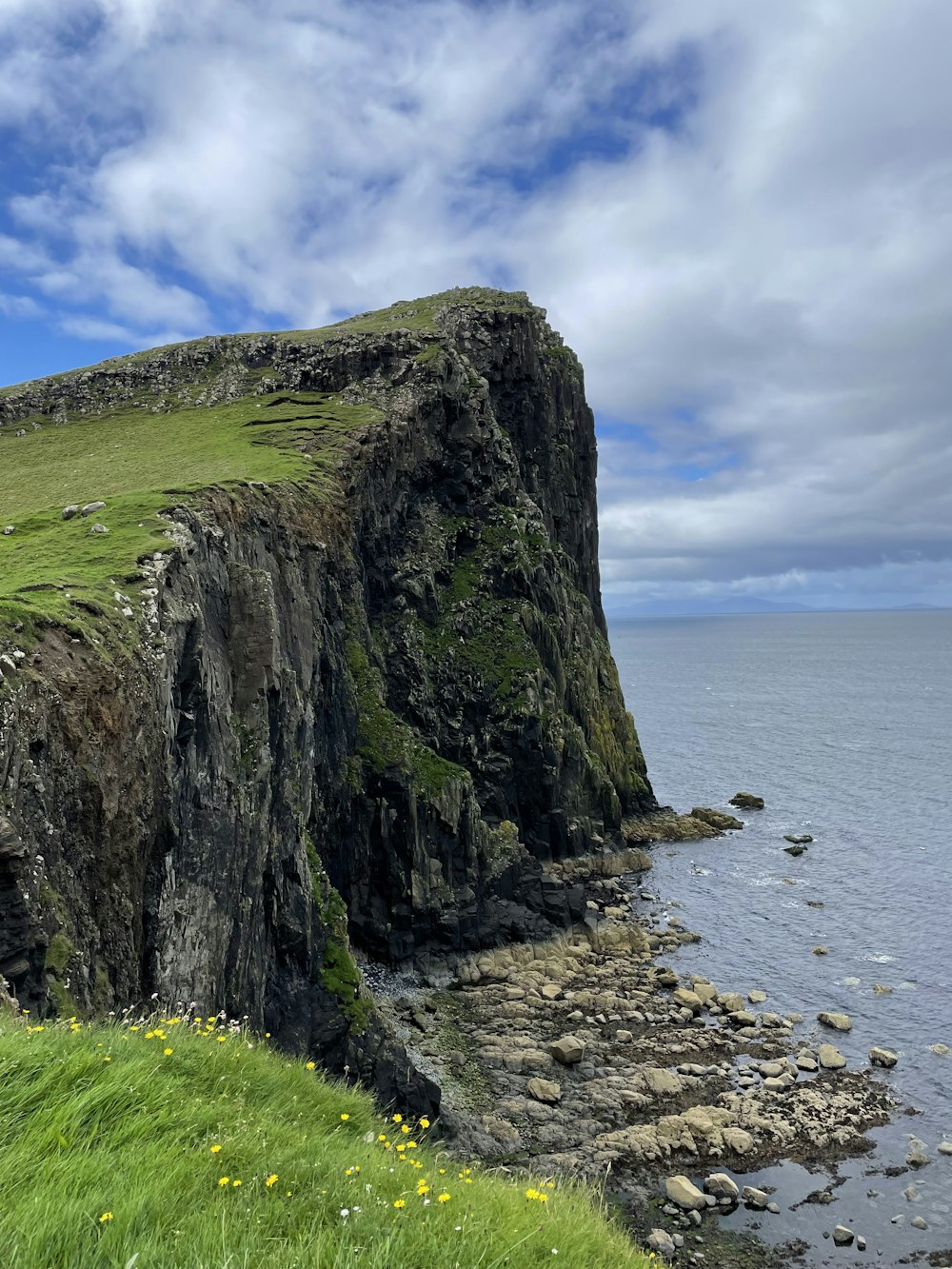 a cliff side with a body of water below