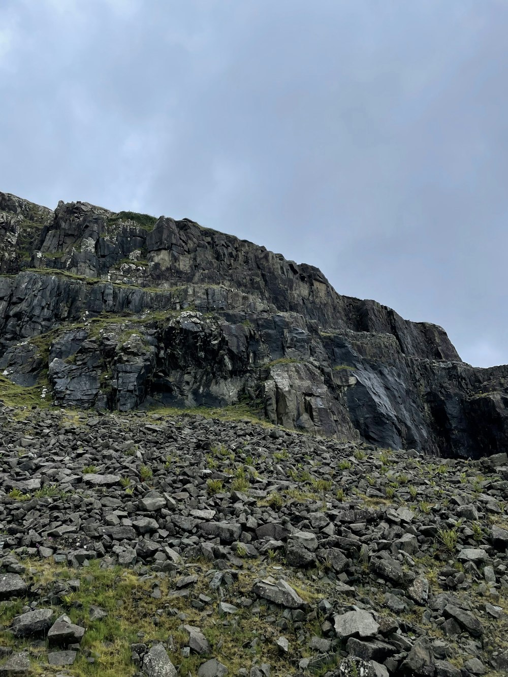 Una montaña rocosa con hierba y rocas