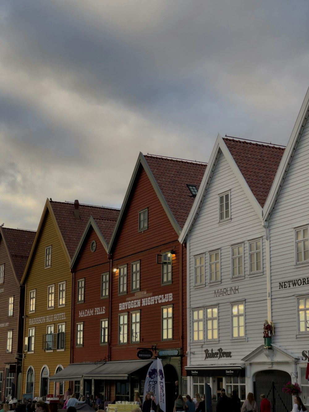 un grupo de edificios con gente caminando con Bryggen en el fondo