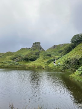 a body of water with hills and trees around it