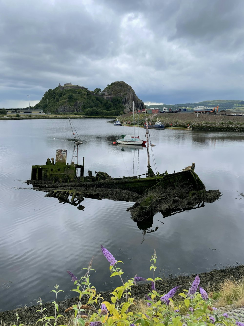 a body of water with boats and a hill in the background