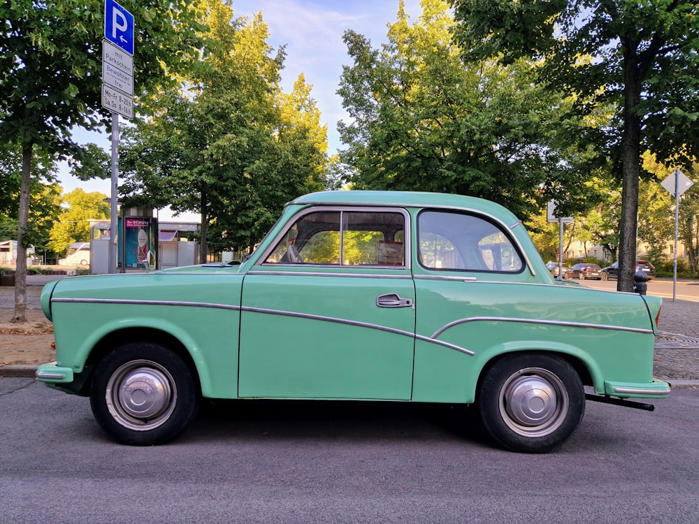 a green car parked on the side of a road