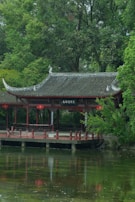 a building with a red roof by a body of water