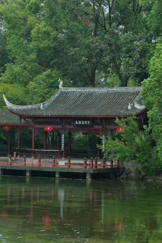 a building with a red roof by a body of water