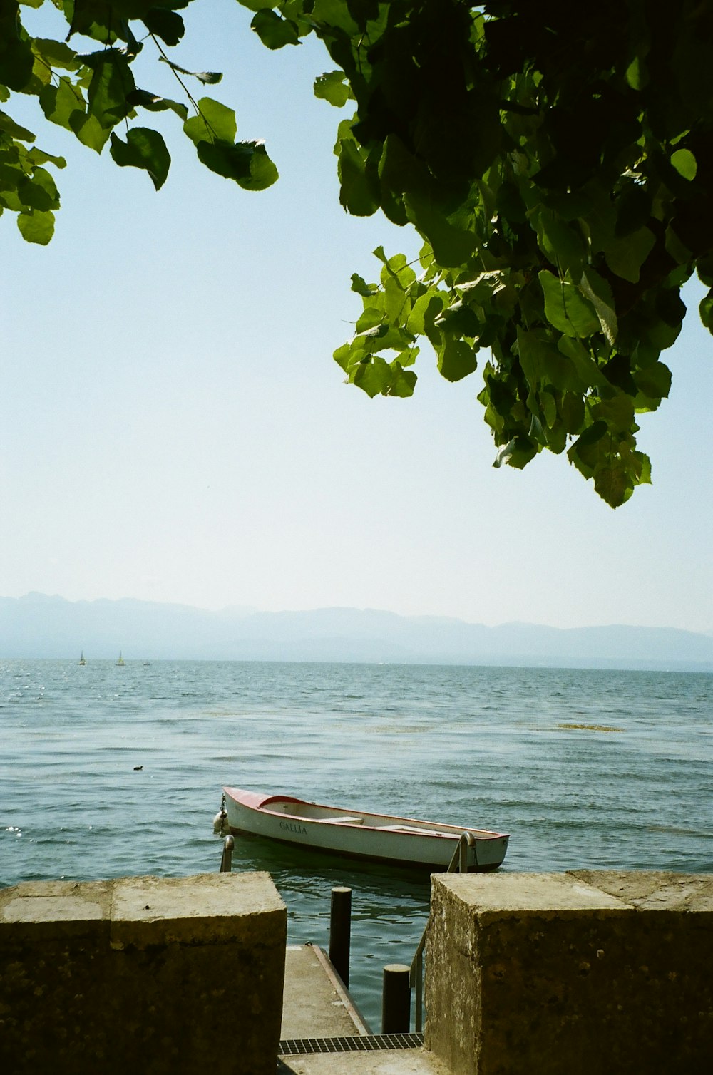 a boat sits on the shore of a lake