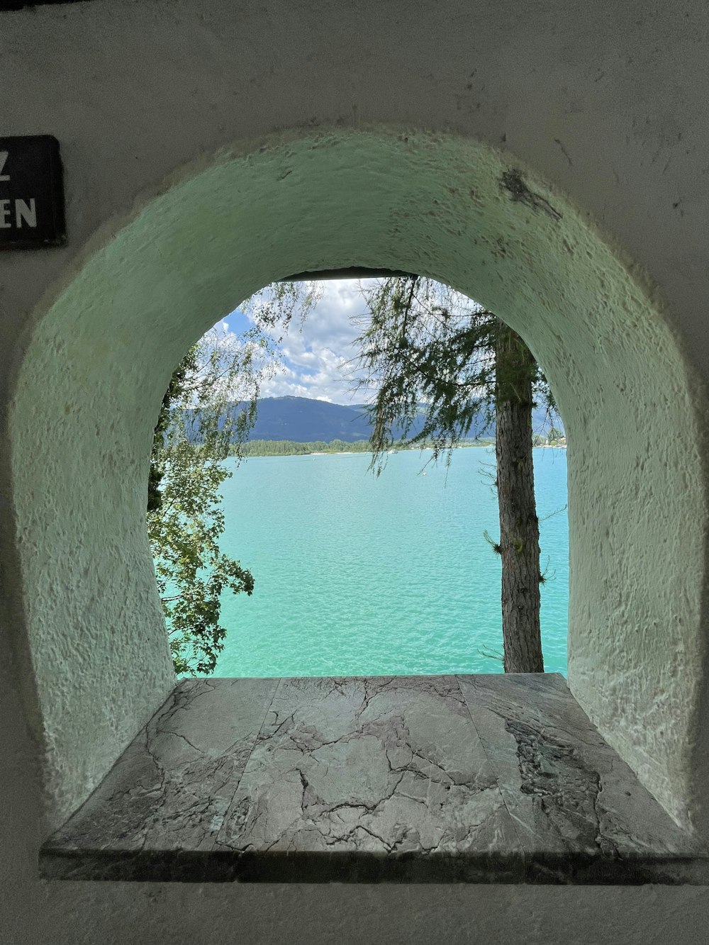 a view of a lake through a stone archway