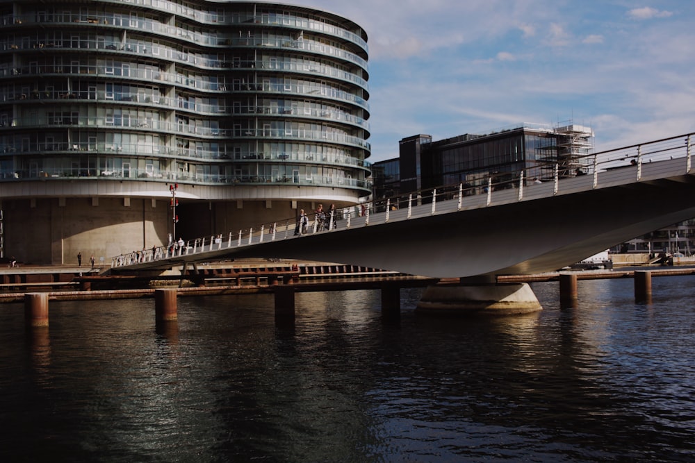 a bridge over water with a building in the background