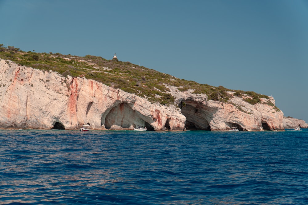 a rocky cliff with a body of water below