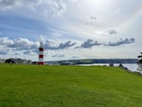 a lighthouse on a grassy hill