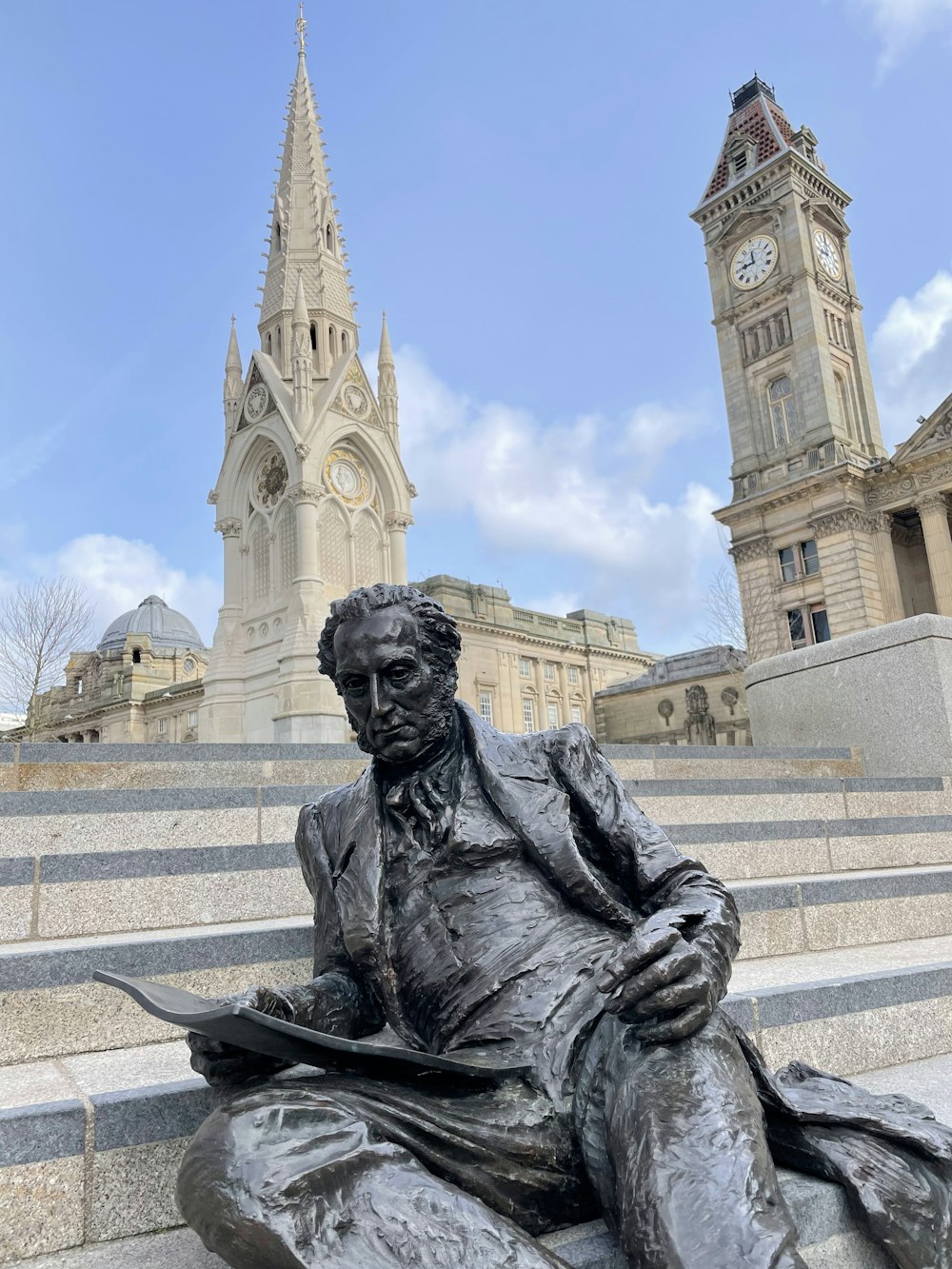 a statue of a person in front of a building with towers