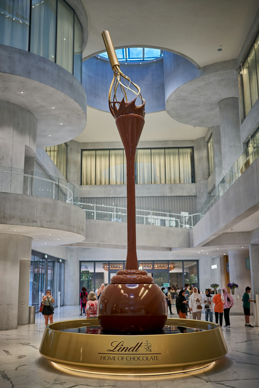 a large red and gold statue in a large building with people