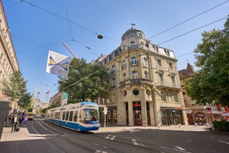 A vibrant street scene in Budapest with trams and historic buildings under a clear sky.