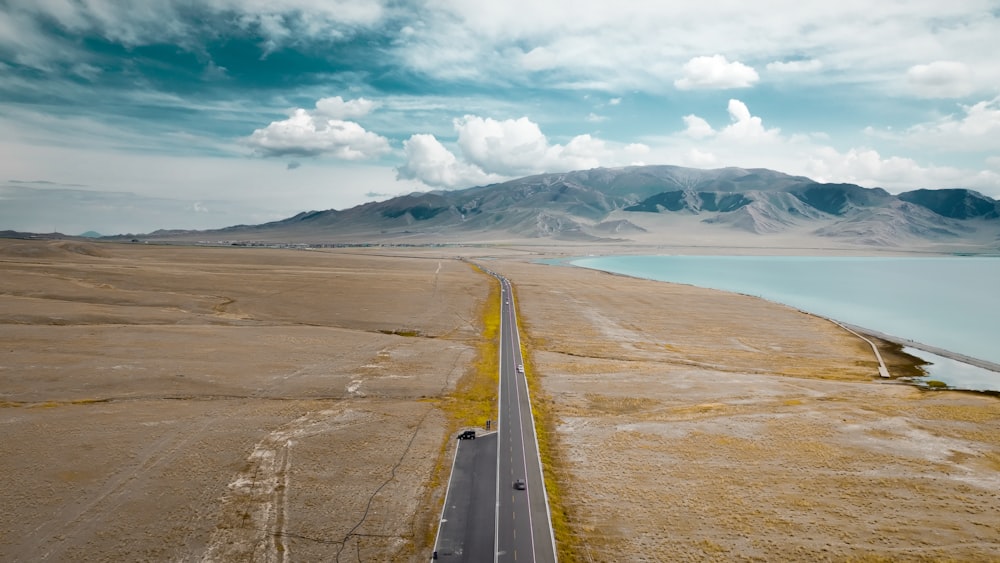 a long straight road with mountains in the background