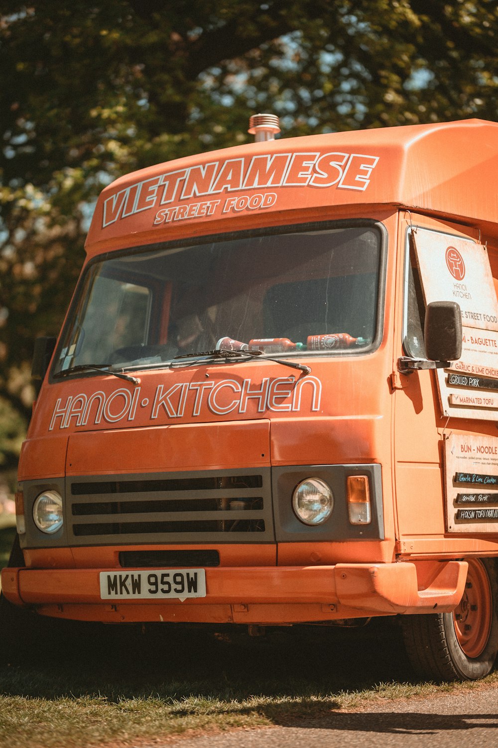 an orange truck parked in front of trees