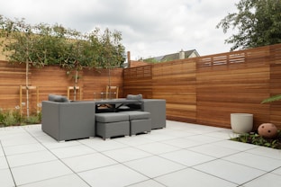 a patio with a couch and a table and chairs