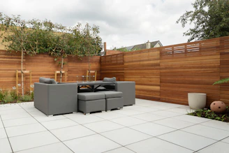 a patio with a couch and a table and chairs
