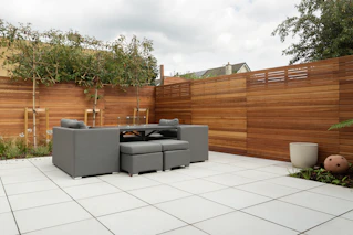 a patio with a couch and a table and chairs