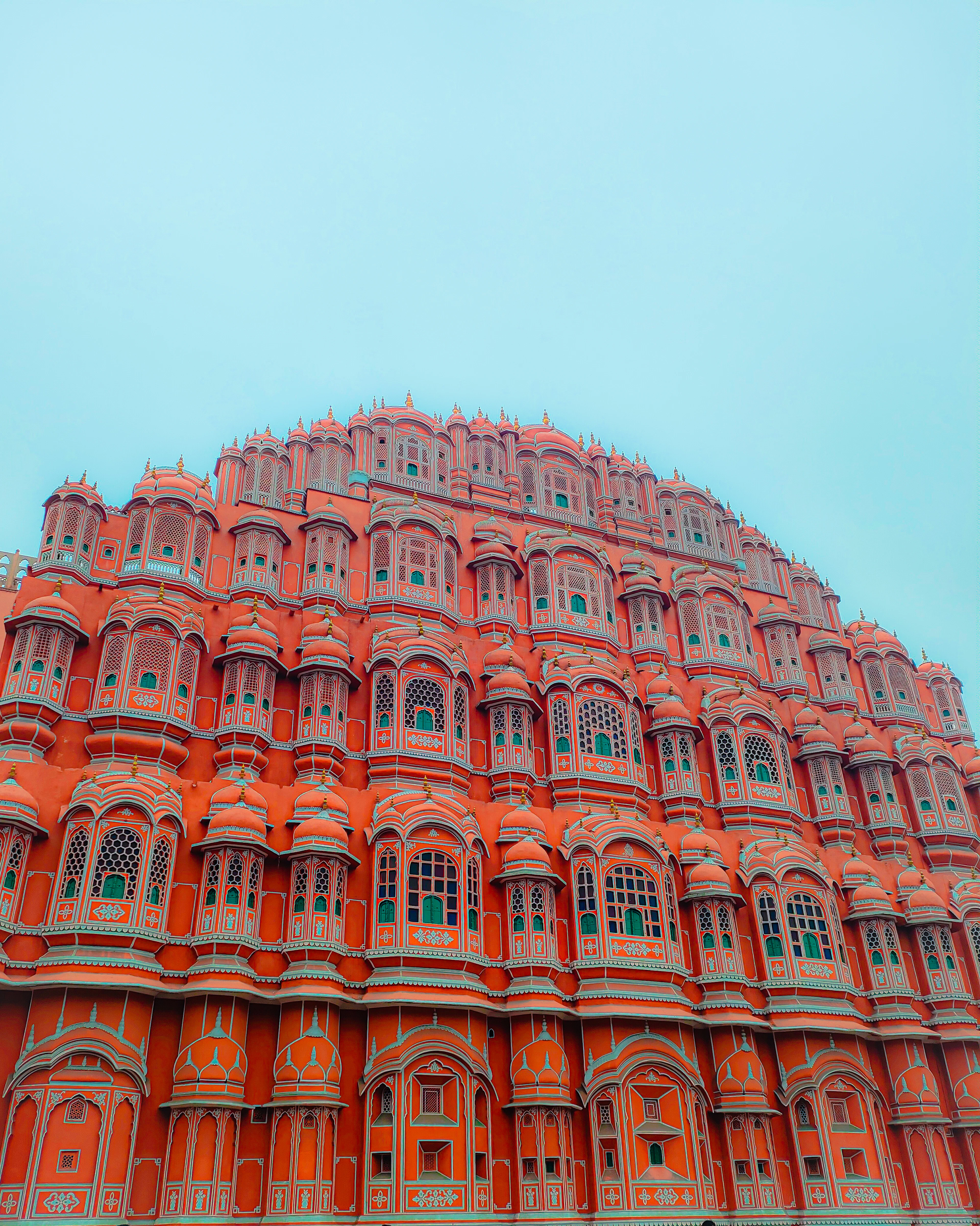 Hawa Mahal's honeycomb pink facade rises sharply against a vivid turquoise sky.