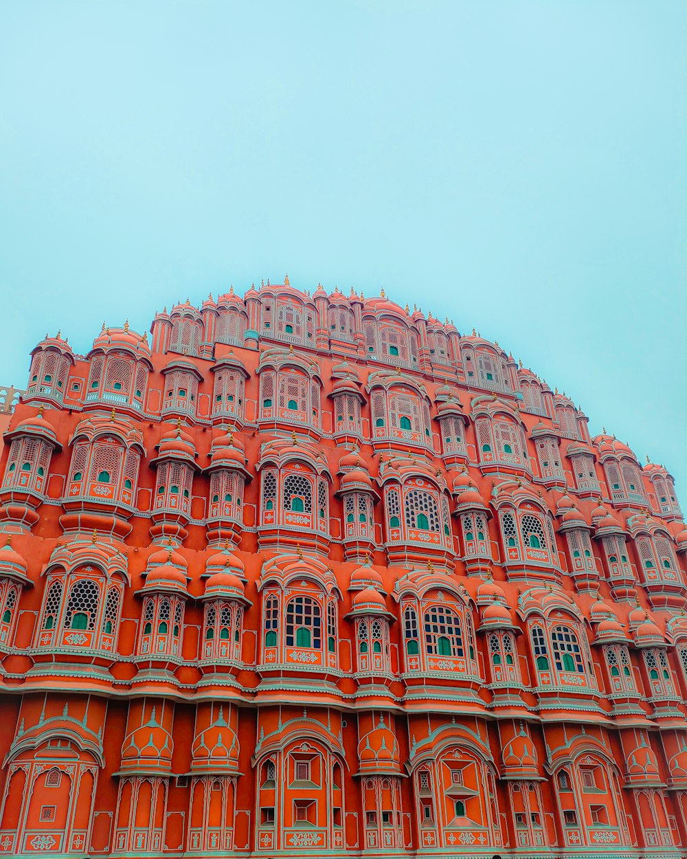 a large building with many windows with Hawa Mahal in the background