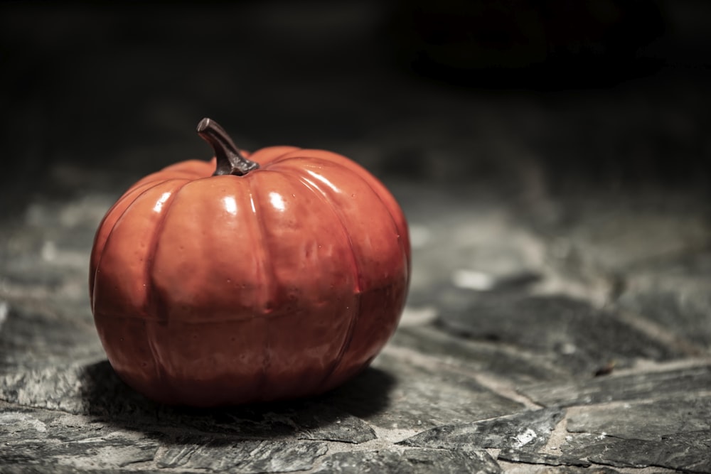 a red pumpkin on a wood surface
