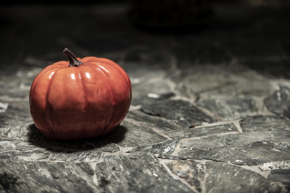 a red apple on a stone surface