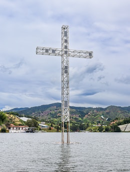 a large metal tower next to a body of water