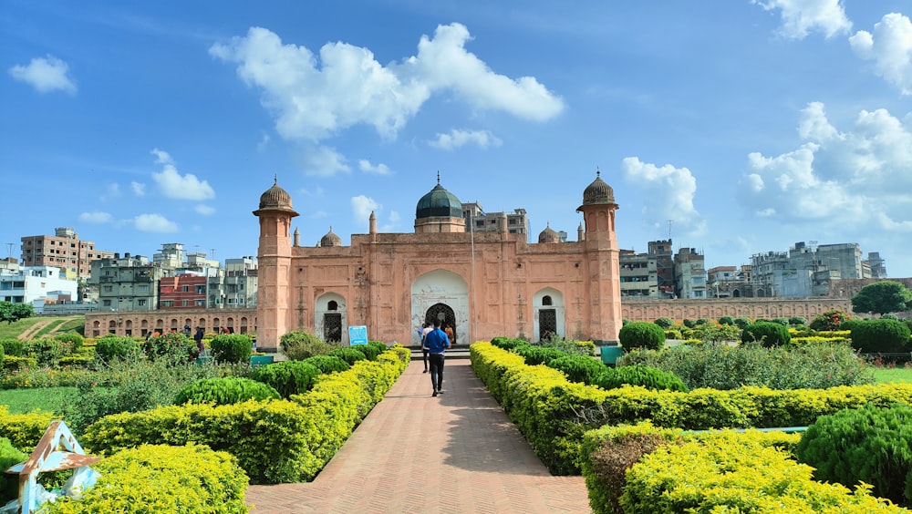 a person walking on a path in front of a large building