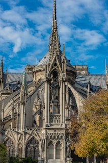 a large ornate building with a statue in front of it with Autun Cathedral in the background