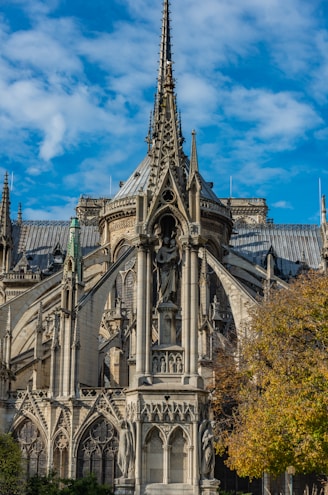 a large ornate building with a statue in front of it with Autun Cathedral in the background