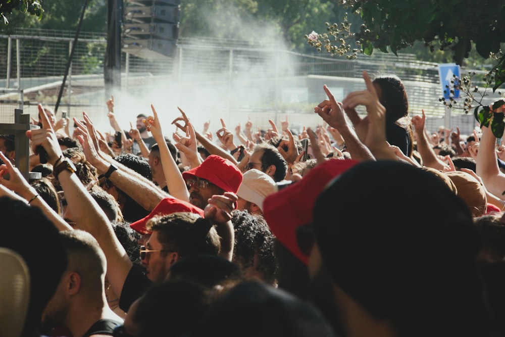 a crowd of people with their hands up in the air