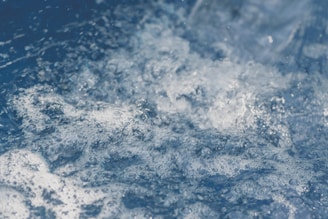 Foamy, churning water in a dynamic motion, capturing the texture and movement of small bubbles and turbulent currents.