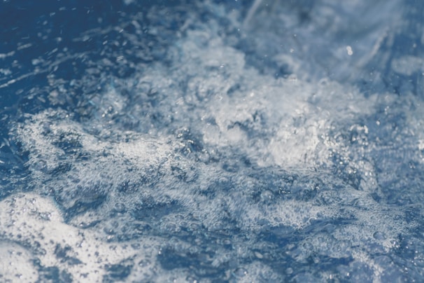 Foamy, churning water in a dynamic motion, capturing the texture and movement of small bubbles and turbulent currents.