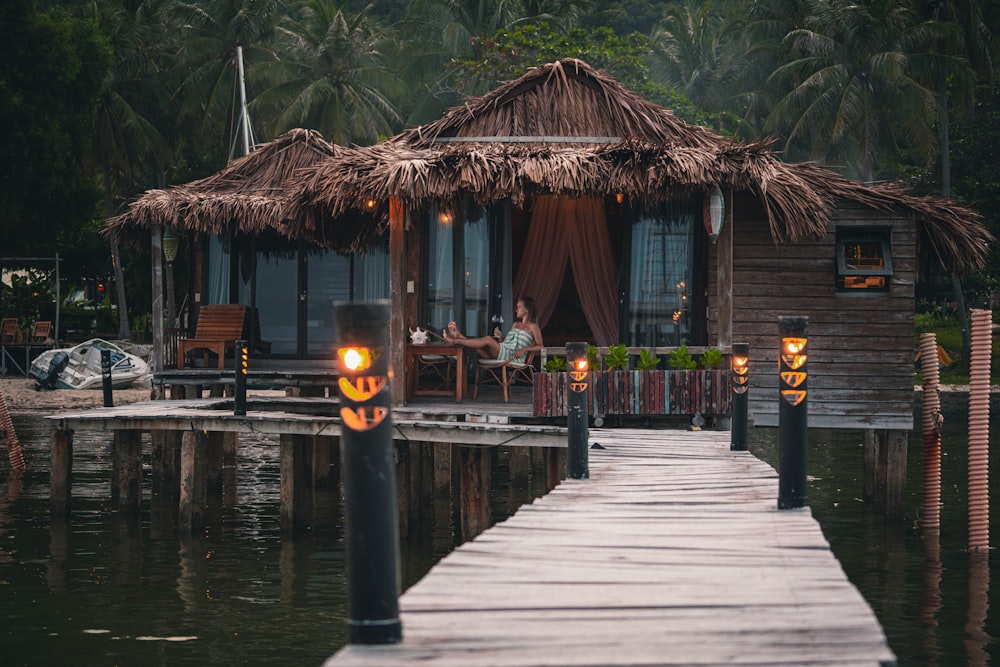 a person sitting at a table on a dock by a house