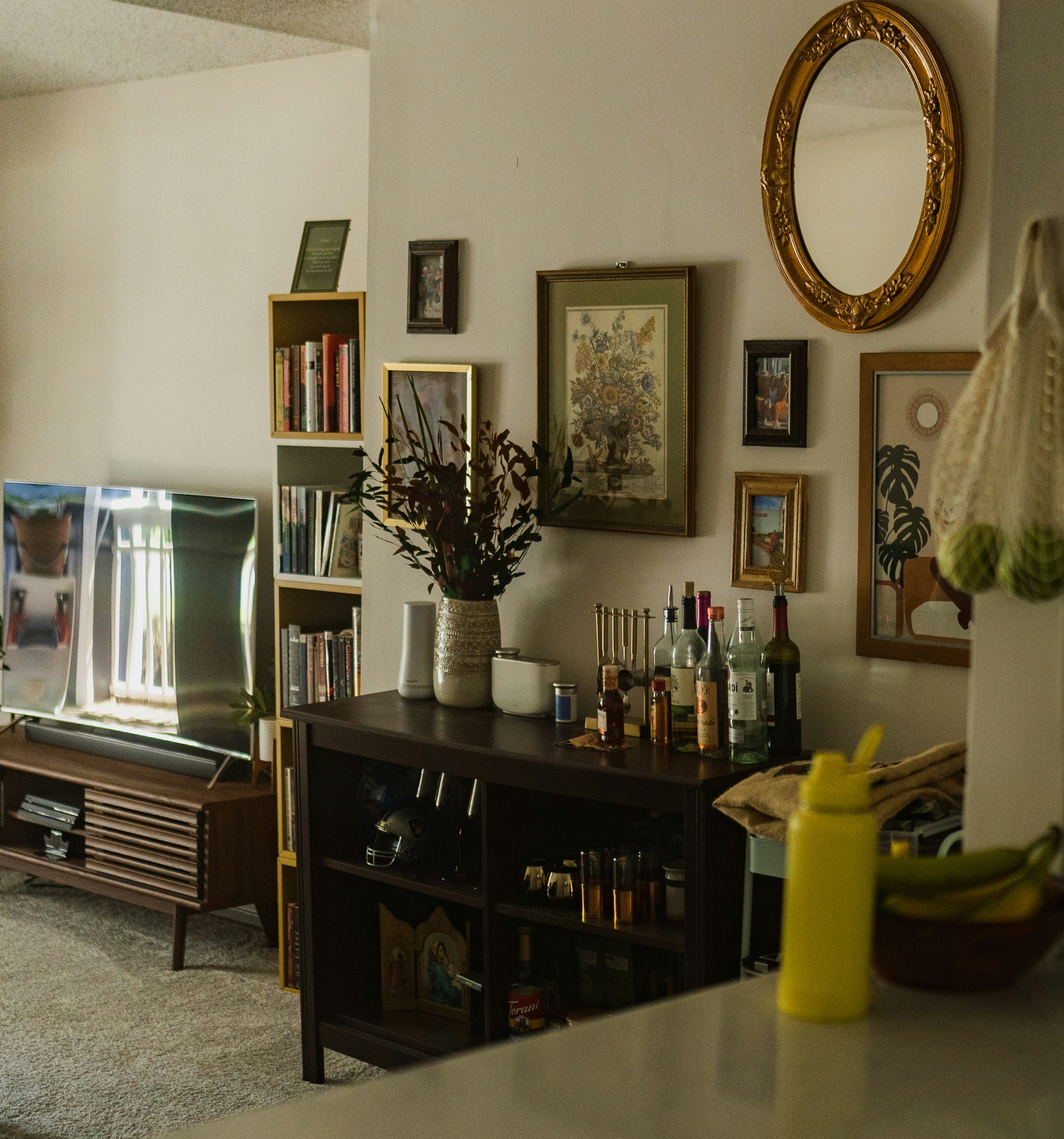 a living room with a tv and wine bottles