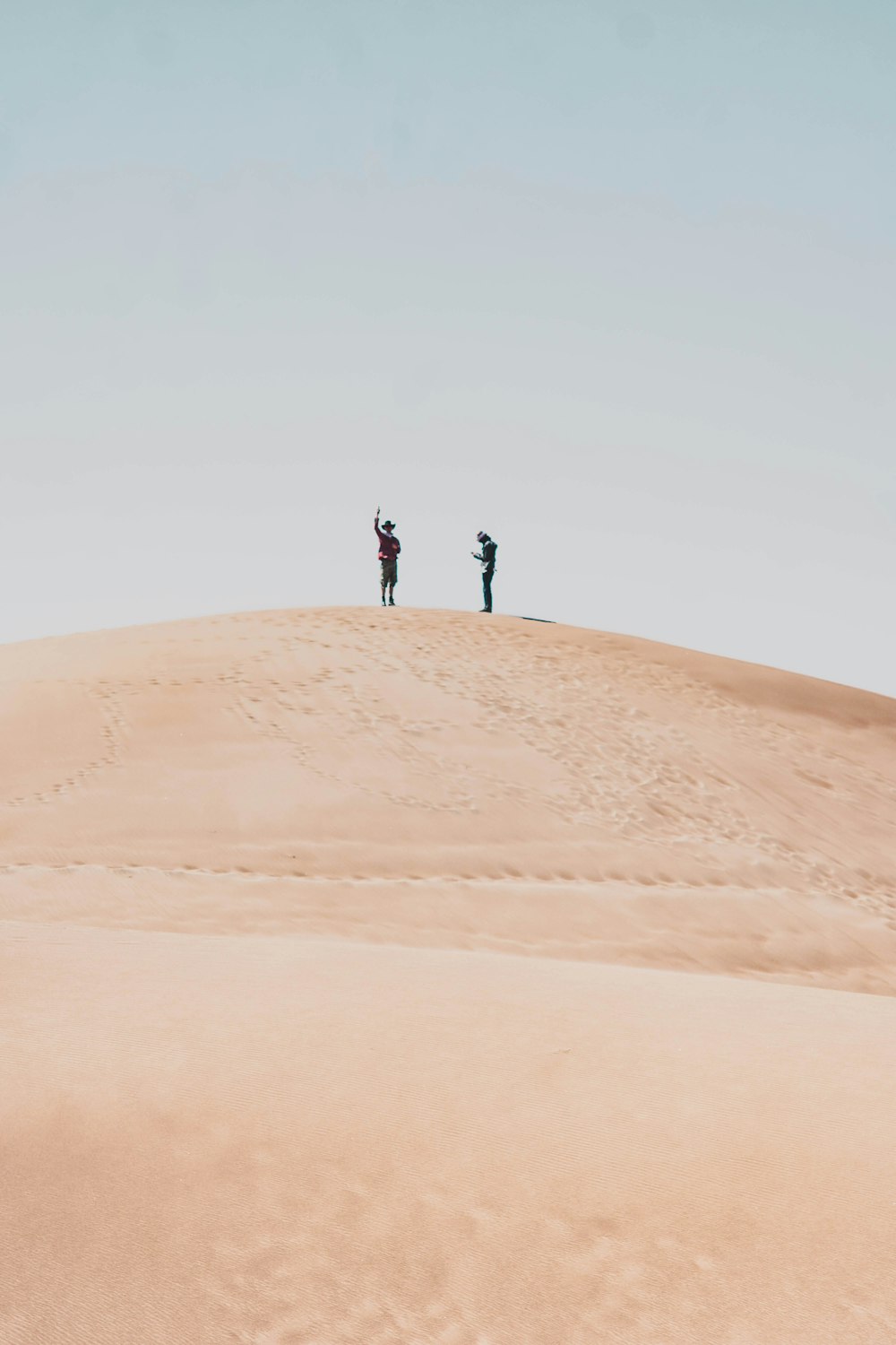 a group of people standing on a sand dune