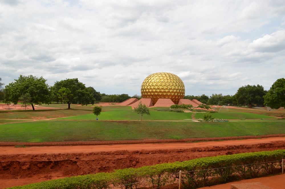 a large green field with a large dome in the middle