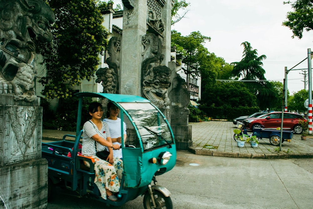 a person and a child on a small blue car