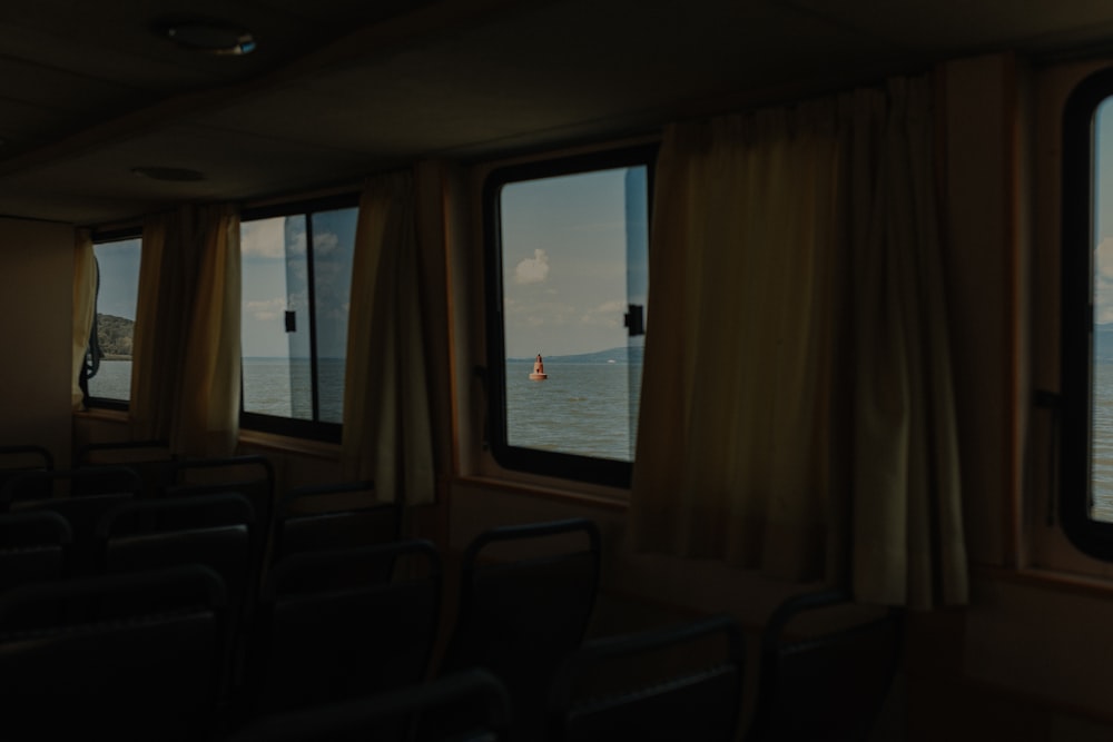 a train with a view of the ocean and a person in the window