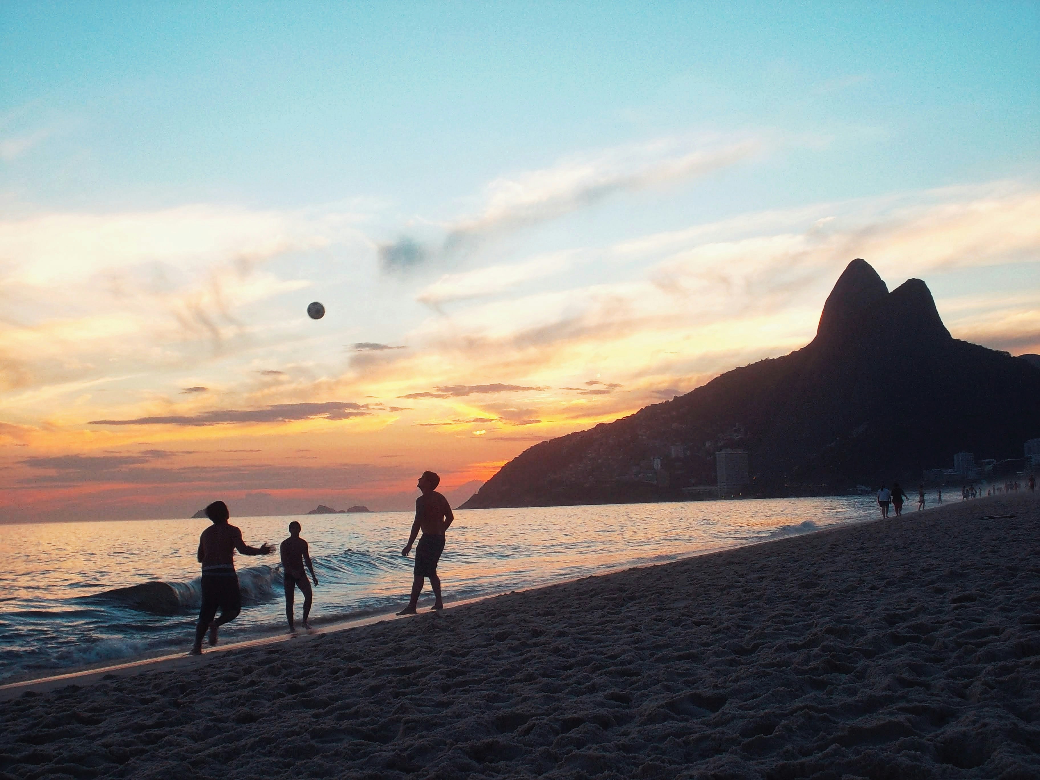 people playing frisbee on a beach