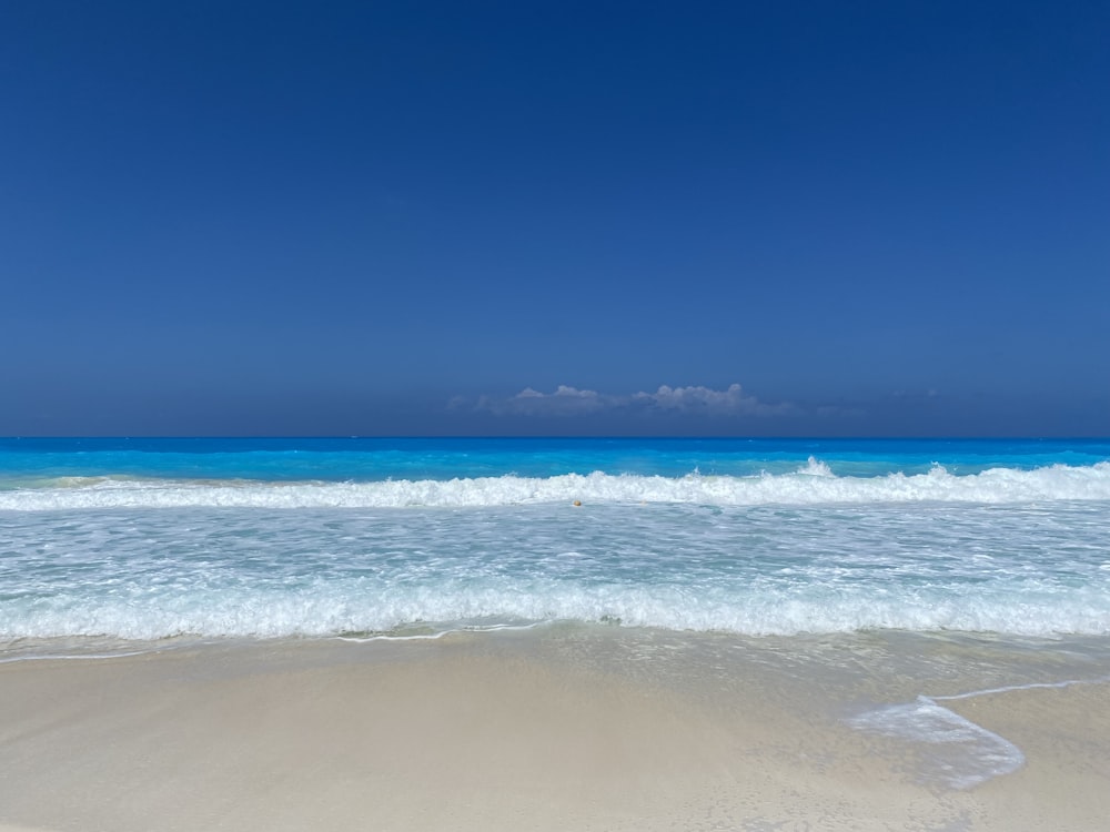 Una playa con olas y un cielo azul